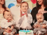 A Family Is Posing For A Picture In Front Of A Birthday Cake . GIF