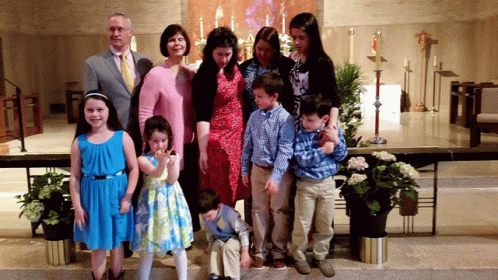 A Family Posing For A Picture In Front Of A Church Altar GIF