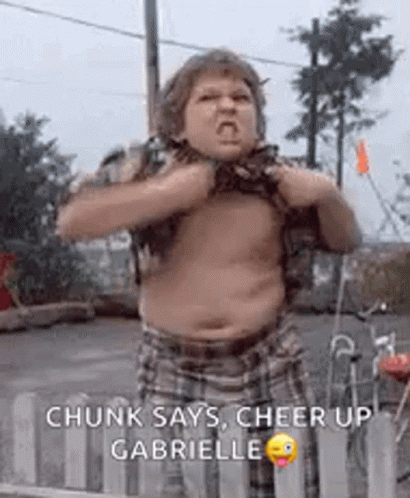 A Fat Boy Is Standing In Front Of A Fence With His Shirt Off And Making A Funny Face . GIF