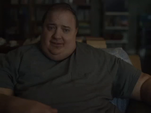 A Fat Man Is Sitting On A Couch And Smiling GIF