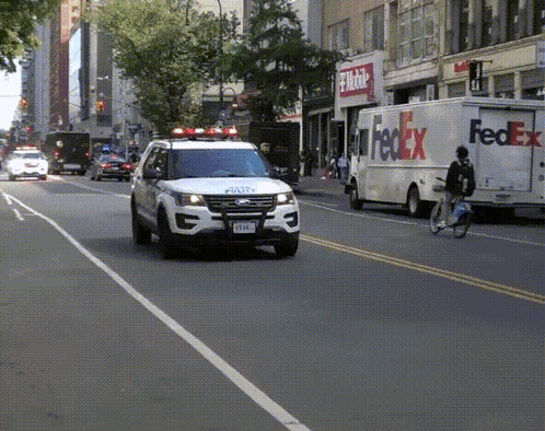 A Fedex Truck Is Driving Down The Street GIF