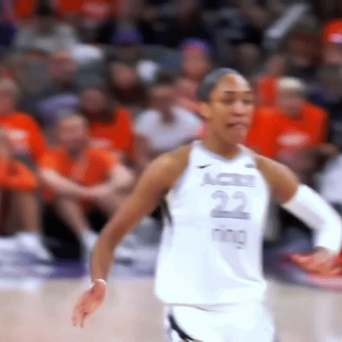 A Female Basketball Player Is Standing On The Court During A Game . GIF