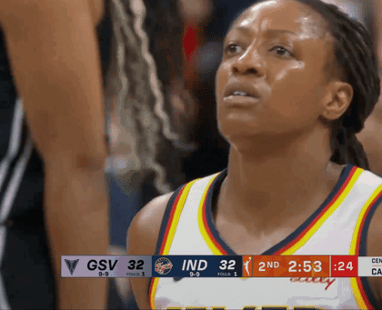 A Female Basketball Player Stands In Front Of A Scoreboard That Says Gsv 32 Ind 32 GIF