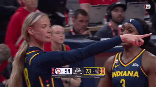 a female basketball player wearing a jersey that says indiana is pointing at another player