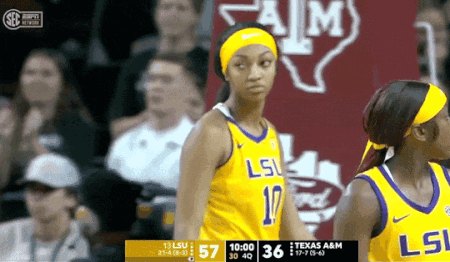 a female basketball player wearing a lsu jersey stands on the court