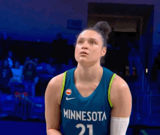 A Female Basketball Player Wearing A Minnesota Jersey Is Standing On A Court GIF