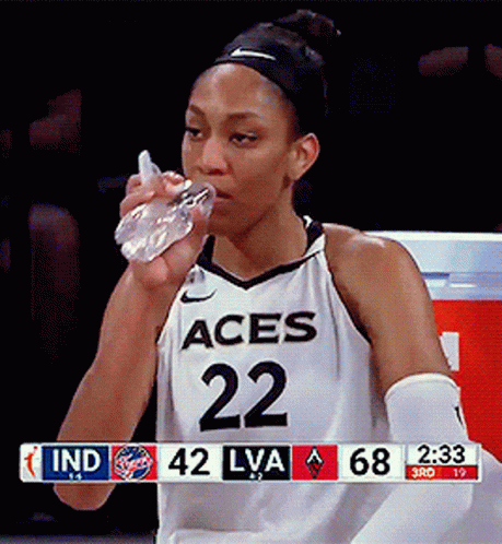 A Female Basketball Player With The Number 22 On Her Jersey Is Drinking Water GIF