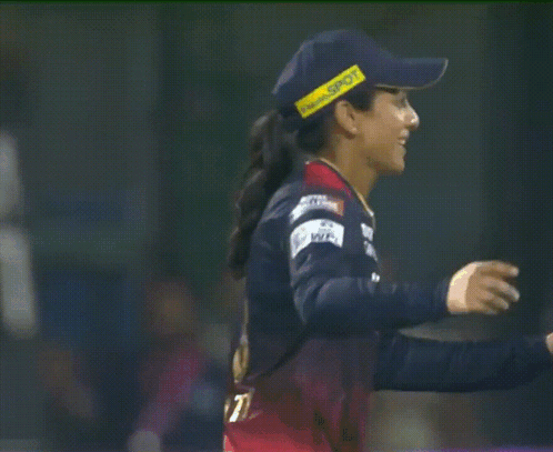 A Female Cricket Player Wearing A Blue Hat With A Yellow Stripe That Says ' Sdn ' On It GIF