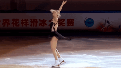 A Female Figure Skater Is Performing In Front Of A Sign That Says World Championship GIF