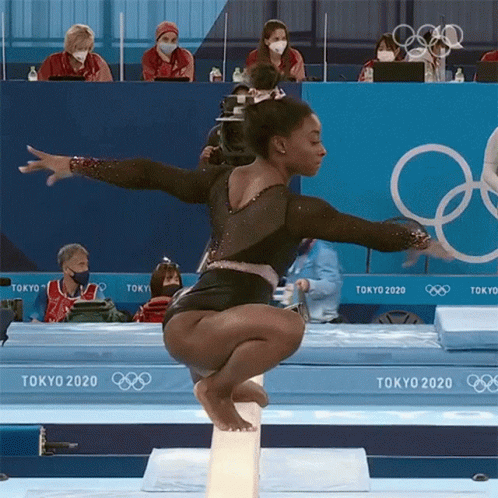 A Female Gymnast Is Doing A Trick On A Balance Beam At The Tokyo Olympics GIF