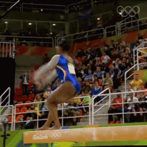 A Female Gymnast Is Performing On A Balance Beam At The Rio 2016 Olympic Games GIF