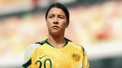 A Female Soccer Player Wearing A Yellow And Green Jersey With The Number 20 On It GIF