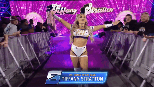 A Female Wrestler Named Tiffany Stratton Is Walking Through A Ring GIF