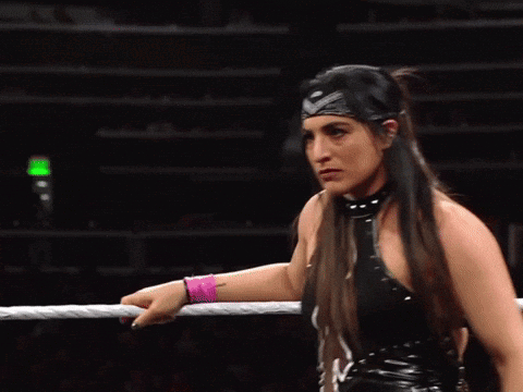 A Female Wrestler Wearing A Headband And A Pink Wristband GIF