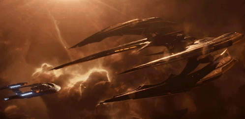 A Few Spaceships Are Flying In A Cloudy Sky GIF