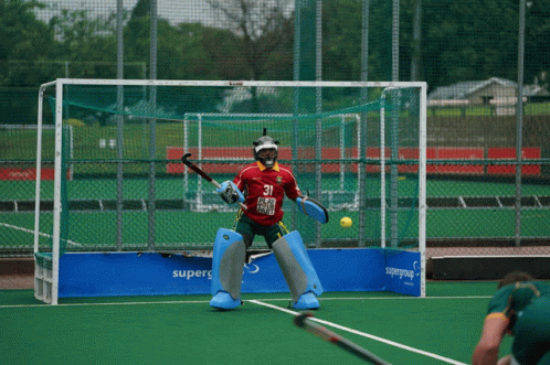A Field Hockey Player Wearing A Red Jersey With The Number 21 On It GIF