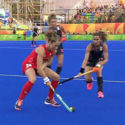 A Field Hockey Player Wearing A Red Uniform With The Number 74 On It GIF