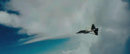A Fighter Jet Is Flying Through A Cloudy Blue Sky With Chinese Writing On The Bottom Right Corner GIF