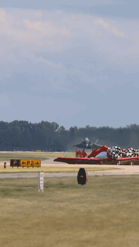 A Fighter Jet Takes Off From A Runway With Trees In The Background GIF