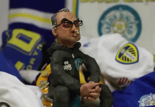 A Figurine Of A Man Smoking A Cigarette With The Word Ndb On His Shirt GIF