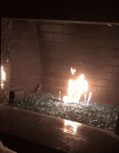 A Fire In A Fireplace With A Lot Of Glass In It GIF