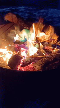 A Fire Is Being Lit With A Can Of Coca Cola In It GIF