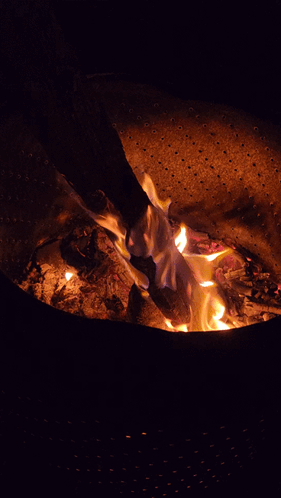 a fire is burning in a metal container with holes in it