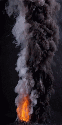 A Fire With Smoke Coming Out Of It On A Dark Background GIF