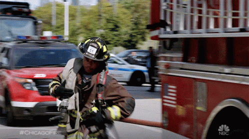 A Fireman In Front Of A Nbc Fire Truck With #Chicagofire Written On The Bottom GIF