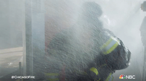 A Fireman Is Spraying Water From A Hose With The Hashtag #Chicagofire On The Bottom GIF