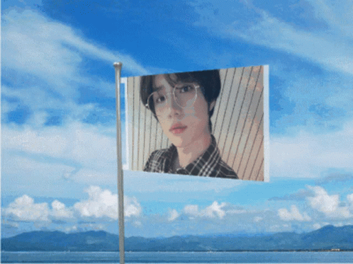 A Flag With A Picture Of A Man With Glasses On It GIF