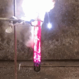 A Flame Is Coming Out Of A Test Tube Filled With Red Liquid GIF