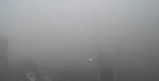 A Foggy City Skyline With A Lot Of Smoke Coming Out Of A Window . GIF