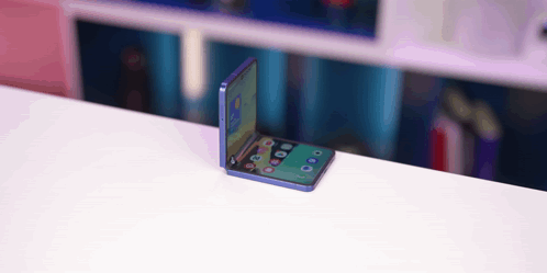 A Folding Phone Is Sitting On A White Table GIF