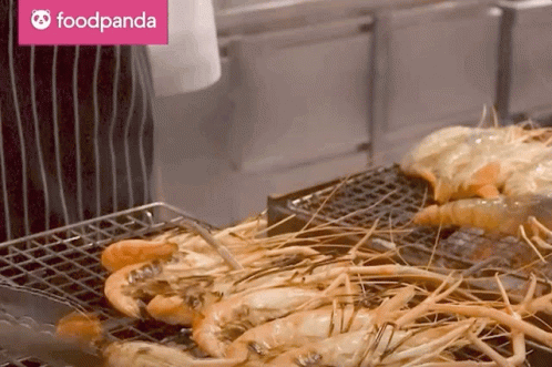A Foodpanda Logo Can Be Seen Behind A Grilled Shrimp GIF
