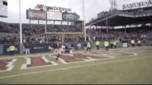 A Football Game Is Being Played In A Stadium Sponsored By Samuel Adams GIF