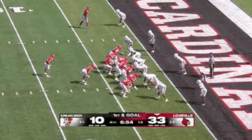a football game is being played on a field with a banner that says cardinals on it .