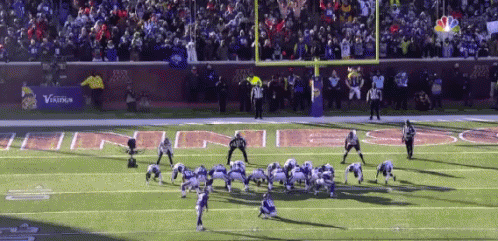 a football game is being played on a field with a banner that says verizon in the background