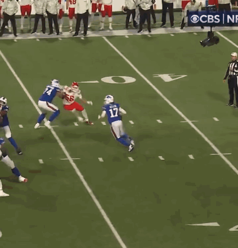 A Football Game Is Being Played On A Field With A Cbs Banner In The Background GIF