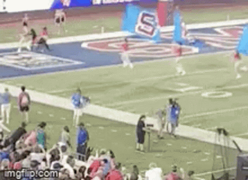 a football game is being played on a field with a crowd of people watching .