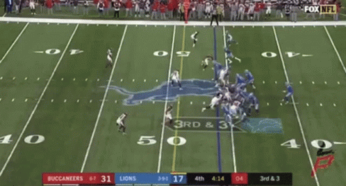 A Football Game Is Being Played On A Field With A Crowd Watching . GIF