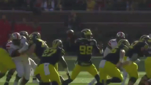 A Football Game Is Being Played On A Field With A Crowd Watching GIF