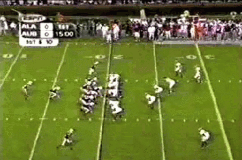 A Football Game Is Being Played On A Field With A Scoreboard In The Background . GIF