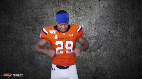 a football player for the camels is adjusting his jersey