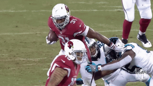 A Football Player For The Cardinals Is Being Tackled By Another Player GIF