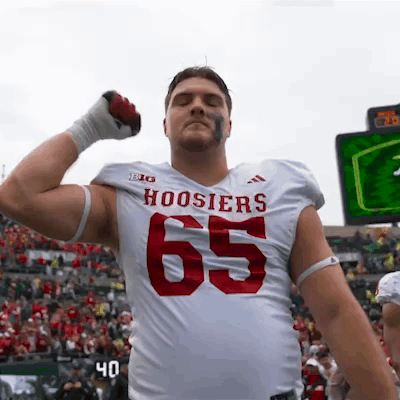 A Football Player For The Hoosier 'S Is Flexing His Muscles GIF