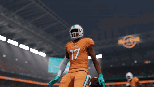 A Football Player For The Miami Dolphins Is Standing In A Stadium GIF