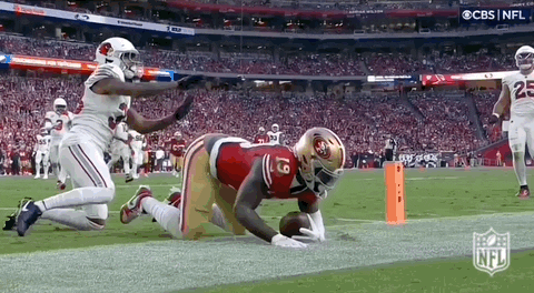 A Football Player In A 49Ers Uniform Is Kneeling On The Field . GIF