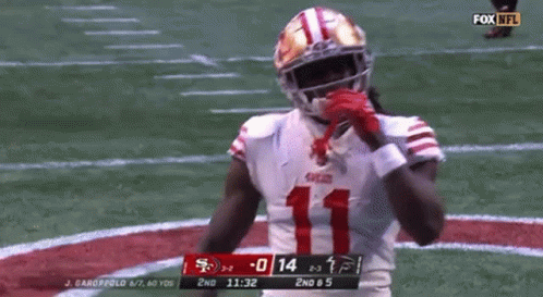 A Football Player In A 49Ers Uniform Is Standing On The Field . GIF