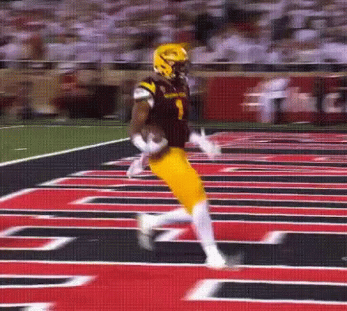 a football player in a black and yellow uniform is running on the field